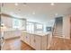 Modern kitchen with a large island, white cabinets, and a view of the staircase and living room at 7505 Woolf Way, Cumming, GA 30028
