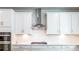 Bright kitchen featuring white cabinetry, quartz countertops, a subway tile backsplash, and stainless steel appliances at 7505 Woolf Way, Cumming, GA 30028