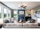 Inviting living room with a cozy fireplace, large windows, comfortable seating, and a TV showing the Beazer Homes logo at 7505 Woolf Way, Cumming, GA 30028