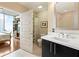 Bright bathroom featuring a single vanity, toilet, and a glass door leading to the bedroom with cityscape views at 1080 Peachtree Ne St # 3213, Atlanta, GA 30309