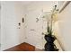 Bright foyer with a chic flower arrangement on a mirrored console, a closet and paneled front door, enhanced by warm wood floors at 1080 Peachtree Ne St # 3213, Atlanta, GA 30309