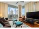 Cozy living room featuring a large window, a balcony, and city views, plus a decorative rug at 1080 Peachtree Ne St # 3213, Atlanta, GA 30309