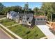 An aerial view of a modern home with lush landscaping, a well-manicured lawn, and a spacious driveway at 115 Nova Ln, Roswell, GA 30075