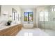 Contemporary bathroom features a double vanity, soaking tub, and glass enclosed shower on light tile floors at 115 Nova Ln, Roswell, GA 30075