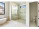 Luxurious bathroom featuring a soaking tub, a spacious glass shower, and natural light from multiple windows at 115 Nova Ln, Roswell, GA 30075