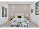 Staged bedroom featuring paneled accent wall, plush chairs, and light-colored wood floors at 115 Nova Ln, Roswell, GA 30075
