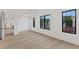 Bright bedroom with light hardwood floors, white walls, and large windows with black frames at 115 Nova Ln, Roswell, GA 30075