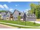 Attractive modern home featuring a three car garage, lush green lawn, and sleek dark exterior on a sunny day at 115 Nova Ln, Roswell, GA 30075