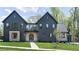 Stunning modern home with dark siding, complemented by well-manicured lawn and beautiful architectural details at 115 Nova Ln, Roswell, GA 30075