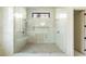 Modern glass-enclosed shower with dual showerheads, a built-in bench, and pebble floor in a bright bathroom at 115 Nova Ln, Roswell, GA 30075