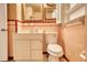 Pink tiled bathroom featuring a toilet, sink, and vanity with storage at 177 Fairview Dr, Fairburn, GA 30213