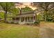 Charming brick home featuring a welcoming front porch, a well-manicured lawn, and an inviting facade at 177 Fairview Dr, Fairburn, GA 30213