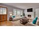 Cozy living room featuring a fireplace, hardwood floors, comfortable seating, and lots of natural light at 177 Fairview Dr, Fairburn, GA 30213