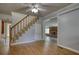 Open concept living room with staircase, hardwood floors and brick fireplace at 177 Fairview Dr, Fairburn, GA 30213