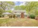 Two-story house with white siding, a brick chimney, and an attached carport with mature trees at 177 Fairview Dr, Fairburn, GA 30213