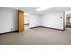 Finished basement with neutral carpeting, painted walls and multiple doorways to additional rooms and storage at 4927 Bedell Ne Rd, Roswell, GA 30075