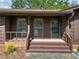 Welcoming front porch featuring brick accents and wood paneling at 4927 Bedell Ne Rd, Roswell, GA 30075