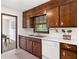 Kitchen featuring wood cabinets, white countertops, and stainless steel sink at 4927 Bedell Ne Rd, Roswell, GA 30075