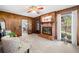 Warm living room with traditional brick fireplace, wood paneling, and large window views at 4927 Bedell Ne Rd, Roswell, GA 30075