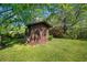 Backyard storage shed featuring a shingled roof and double doors for easy access at 4927 Bedell Ne Rd, Roswell, GA 30075