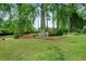 A lush green backyard with a brick retaining wall and mature shade trees at 5839 Darry Cir, Norcross, GA 30093