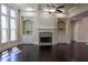 Bright living room boasts a fireplace with custom shelving, large windows, dark hardwood floors, and a ceiling fan at 610 Big Bend Trl, Sugar Hill, GA 30518