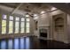 Living room with fireplace, built-in shelving, large windows, dark hardwood floors, coffered ceilings, and ceiling fan at 610 Big Bend Trl, Sugar Hill, GA 30518