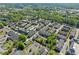 An aerial view shows the neighborhood community, the pool, and many trees surrounding the homes at 6135 Redwine St, Norcross, GA 30071
