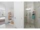 Contemporary bathroom showcasing a glass shower, tiled walls, and views of tub and bedroom in background at 6135 Redwine St, Norcross, GA 30071
