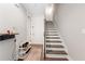 Neutral entryway featuring hardwood floors, wooden stairs, and a built-in black shelving unit at 6135 Redwine St, Norcross, GA 30071