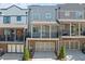 Townhome with gray siding, brick accents, and balcony with black railings above garage at 6135 Redwine St, Norcross, GA 30071