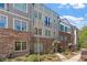 Townhome exteriors featuring brick accents, neutral siding, and well-manicured landscaping at 6135 Redwine St, Norcross, GA 30071