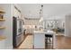 Open kitchen with stainless steel appliances, white cabinets, island with barstool seating and dining room view at 6135 Redwine St, Norcross, GA 30071