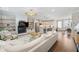 Bright open-concept living room with fireplace and view of the kitchen's island and stainless steel appliances at 6135 Redwine St, Norcross, GA 30071
