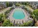 Aerial view of a community pool surrounded by lounge chairs, lush landscaping, and greenery at 6135 Redwine St, Norcross, GA 30071