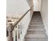 Carpeted staircase with white railing leads to upper levels, with kitchen visible in the background at 6135 Redwine St, Norcross, GA 30071
