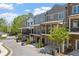 View of the street lined with upscale townhomes, mature trees, and well-maintained landscaping at 6135 Redwine St, Norcross, GA 30071