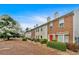 Exterior view of the townhome row, with neat landscaping, red doors, and blooming tree at 992 Old Holcomb Bridge Rd, Roswell, GA 30076