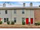 Charming townhome featuring a red front door, neutral siding, and well-maintained landscaping at 992 Old Holcomb Bridge Rd, Roswell, GA 30076