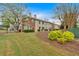 Well-manicured lawn leading to a row of townhomes with red front doors and brick accents at 992 Old Holcomb Bridge Rd, Roswell, GA 30076
