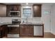 Modern kitchen features stainless steel appliances, granite counters, white subway tile backsplash and dark wood cabinets at 1587 Wainwright Se Dr, Atlanta, GA 30316