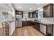 Well-lit kitchen with wood floors, stainless steel appliances, granite counters and dark wood cabinets at 1587 Wainwright Se Dr, Atlanta, GA 30316