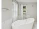 Bright bathroom featuring a modern tub, white curtains, and tile accents at 2988 Chipmunk Se Trl, Marietta, GA 30067