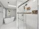 Luxurious bathroom featuring a large glass shower, standalone tub, tiled floors, and a skylight at 2988 Chipmunk Se Trl, Marietta, GA 30067