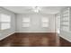 Bedroom with hard surface floors, two windows, a ceiling fan, and built-in shelving at 2988 Chipmunk Se Trl, Marietta, GA 30067
