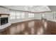 Bright living room featuring hardwood floors, a white brick fireplace, and a tray ceiling with ceiling fans at 2988 Chipmunk Se Trl, Marietta, GA 30067