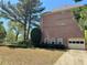 Side view of home showcasing brick facade, attached garage, and a beautifully landscaped yard at 680 Estate Club Cir, Roswell, GA 30075