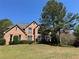 Beautiful two-story brick home with mature landscaping and a well-manicured lawn at 680 Estate Club Cir, Roswell, GA 30075