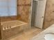 Bathroom featuring soaking tub with tile surround, tile flooring, and white door at 863 Fairwood Pointe Nw, Acworth, GA 30101