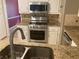 Close up on a kitchen island with stainless appliances, tiled backsplash, and granite countertops at 863 Fairwood Pointe Nw, Acworth, GA 30101